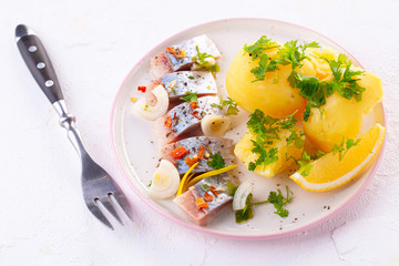 pieces of salted herring in spices with boiled potatoes