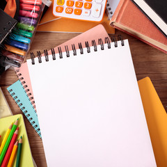 Fototapeta na wymiar Busy student's desk with blank sketch pad