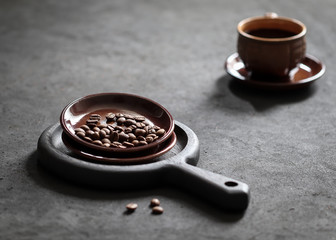 Still life black coffee in a Cup with coffee beans on a dark background