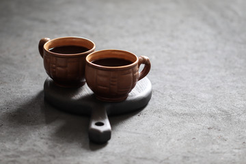 Still life black coffee in a Cup with coffee beans on a dark background