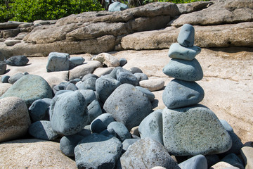 Fototapeta na wymiar stacked piled up zen stone rocks on the seashore beach 