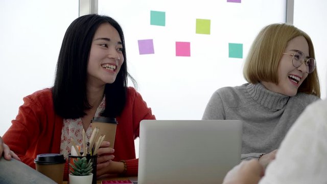 Young Asian businesswoman is sitting, meeting, talking with colleagues at the office with determination, with a happy smile and learning experience from the leader. Concept Positive thinking