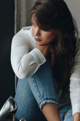 Fototapeta premium Beautiful young woman wearing white blouse and blue jeans