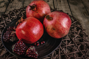 Pomegranate on an old wooden table with rattan