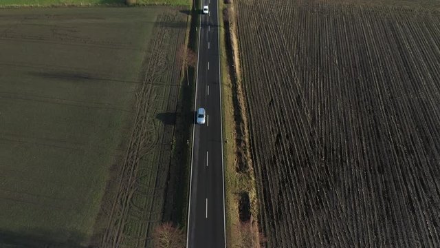 Lange gerade Landstraße mit fahrenden Autos aus der Luft gefilmt - Drohnenaufnahme Draufsicht