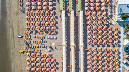 Top down drone aerial view of the umbrellas and gazebos on Italian sandy beaches. Riccione, Italy. Adriatic coast. Emilia Romagna. Summer and holiday time