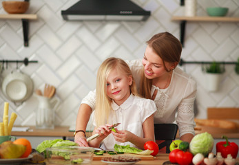 Mother teaches her child daughter how to cook in kitchen, parenthood and healthy lifestyle, nutrition