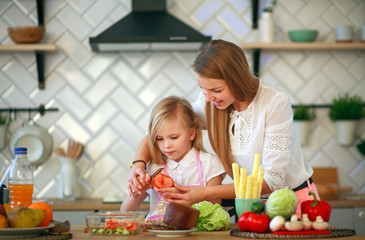 Mother teaches her child daughter how to cook in kitchen, parenthood and healthy lifestyle, nutrition