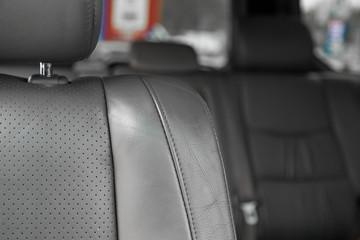 Upholstery of the seats of the passenger compartment of a luxury car with gray perforated genuine...