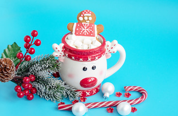 Christmas Cup of hot chocolate with marshmallow and gingerbread man on a blue background. Creative concept of New year and Christmas