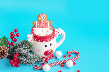 Christmas Cup of hot chocolate with marshmallow and gingerbread man on a blue background. Creative concept of New year and Christmas