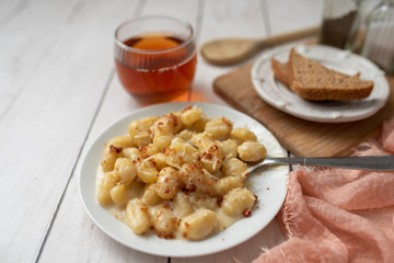 Cheese gnocchi with cheese sauce and bacon bits for garnish on top