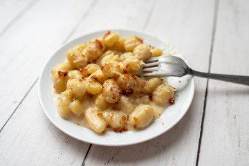 Cheese gnocchi with cheese sauce and bacon bits for garnish on top