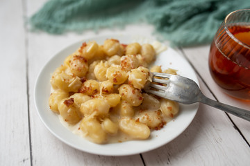 Cheese gnocchi with cheese sauce and bacon bits for garnish on top