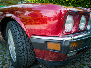 Detail shot of headlight of a red vintage car