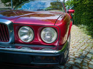 Detail shot of headlight of a red vintage car