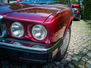 Detail shot of headlight of a red vintage car