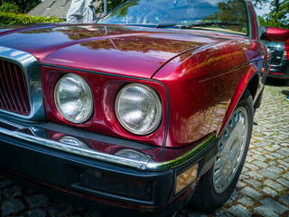 Detail shot of headlight of a red vintage car