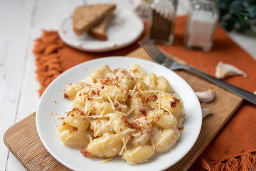 Cheese gnocchi with cheese sauce and bacon bits for garnish on top