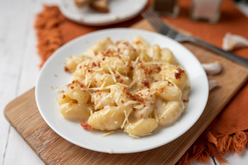 Cheese gnocchi with cheese sauce and bacon bits for garnish on top