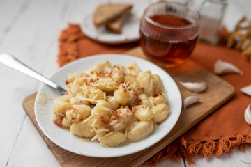Cheese gnocchi with cheese sauce and bacon bits for garnish on top