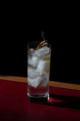Gin Tonic, a cocktail with gin and tonic water, garnished with charred lemon and lavender