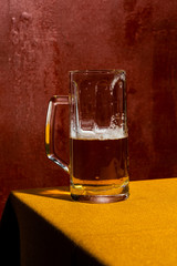 Half empty blonde beer mug, Ale or Lager. Colorful background