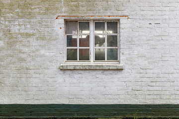 Alte weiße Backsteinwand mit Fenster, weiße Farbe, Moos