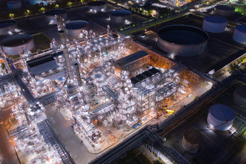 Aerial view oil and gas industrial, Refinery factory oil storage tank and pipeline steel at night