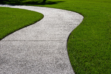 A thick carpet of zoysia grass and an oyster shell tabby pathway suggest the abstract concept of a...