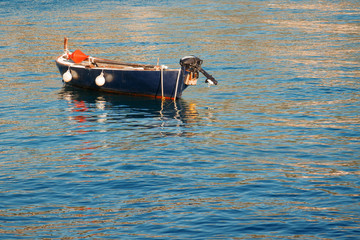 Empty blue boat with buoys is standing in the middle of the sea