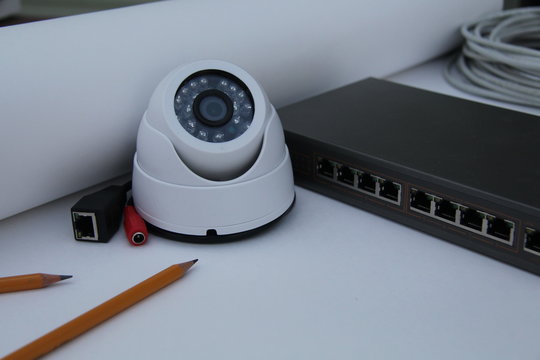 CCTV camera on the table with drawings and equipment for building a security system