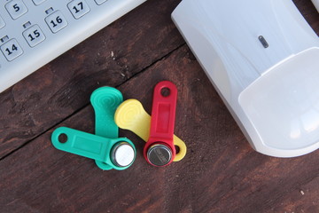 iButton Touch Memory keys in different colors on the table with equipment and sensors for security and security