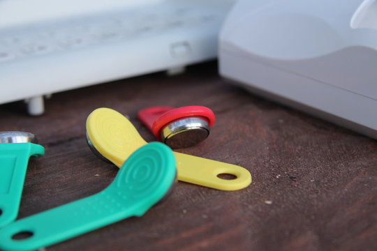 iButton Touch Memory keys in different colors on the table with equipment and sensors for security and security