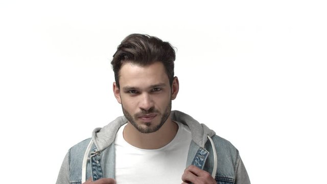 Slow-motion handome and coquettish, stylish bearded hipster guy feeling confident and sassy, smiling romantic and flirty, looking daring and assertive as checking out sexy person, white background