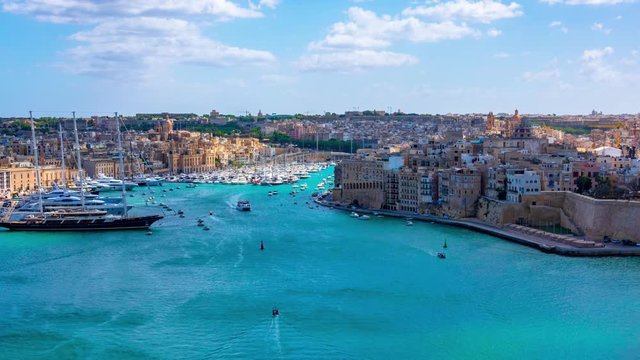 Malta. View from Valletta coast to the Birgu city with Fort St. Angelo, marina with a lot of ships and luxury yachts in azure sea. Time lapse