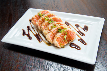 raw sesame salmon sashimi in shoyo hashi sauce on white plate, asian food, japanese cuisine, asian food, japanese cuisine