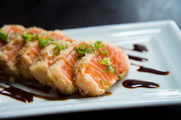 raw sesame salmon sashimi in shoyo hashi sauce on white plate, asian food, japanese cuisine