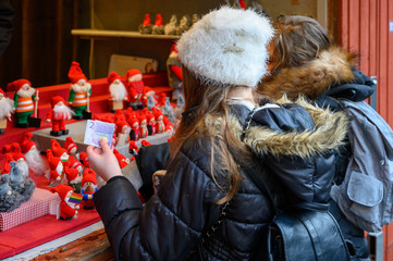 Girl purchases gifts in the Christmas market in Stockholm Old Town