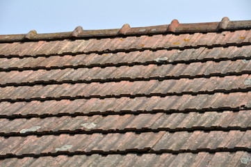 On the roof of the house is an old red tile