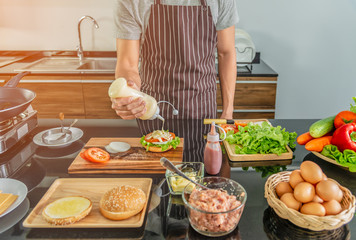 Young chef man preparing delicious burger