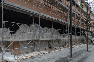 A building in a scaffolding. Construction waste. Stockholm