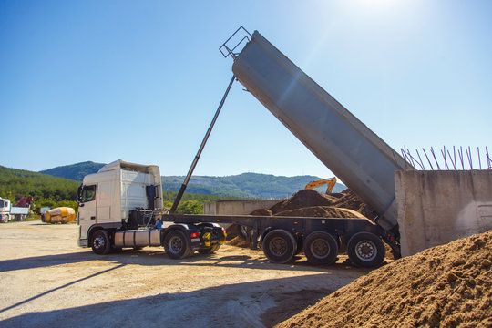 Dump truck unloads from the body of the sand at the concrete plant. 
