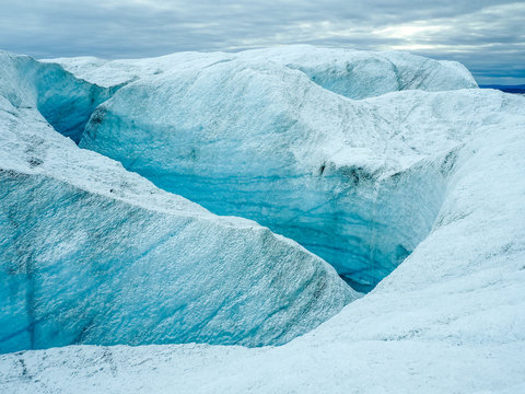 Glacier crevasses and deep ice chasm in Greenland, copy space