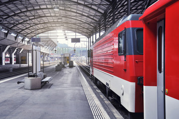 Passenger train stands by the station platform before departure. Luzern. Switzerland.