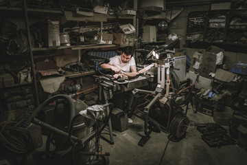 homem consertando boneco robot na garagem