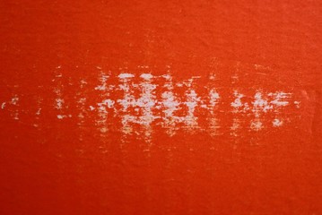 red paper texture with white scuffs on an  piece of cardboard