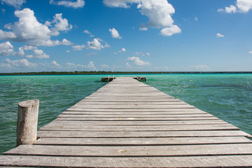 Wooden dock on the beautiful colored caribbean lake at Bacalar