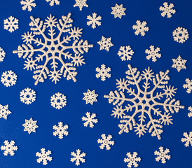 Christmas  festive blue background, with a beautiful pattern of white snowflakes of different sizes, similar to a frosty pattern