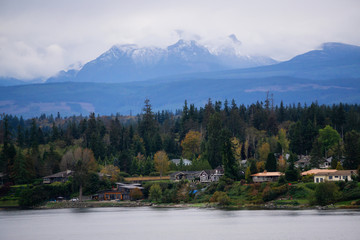 Campbell River, Vancouver Island, British Columbia, Canada. Beautiful view of residential homes on the ocean shore during a cloudy evening.